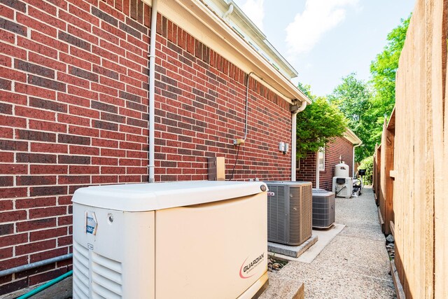 view of home's exterior with brick siding and central AC unit