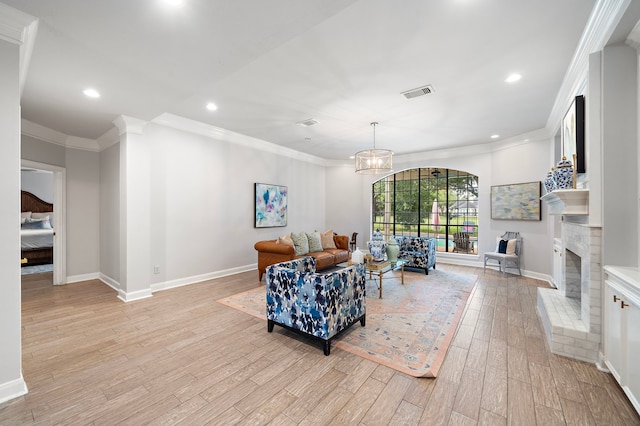 32743 Weybridge St, Fulshear, TX 77441 - living area featuring light wood-type flooring, crown molding, recessed lighting, a chandelier, and a fireplace