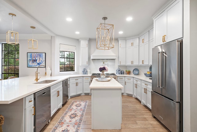 32743 Weybridge St, Fulshear, TX 77441 - kitchen with appliances with stainless steel finishes, recessed lighting, a center island, light countertops, and light wood-style floors
