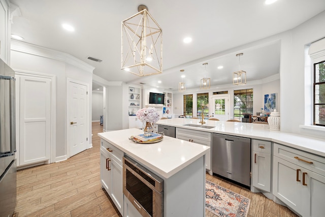 32743 Weybridge St, Fulshear, TX 77441 - kitchen with stainless steel appliances, ornamental molding, open floor plan, light countertops, and recessed lighting