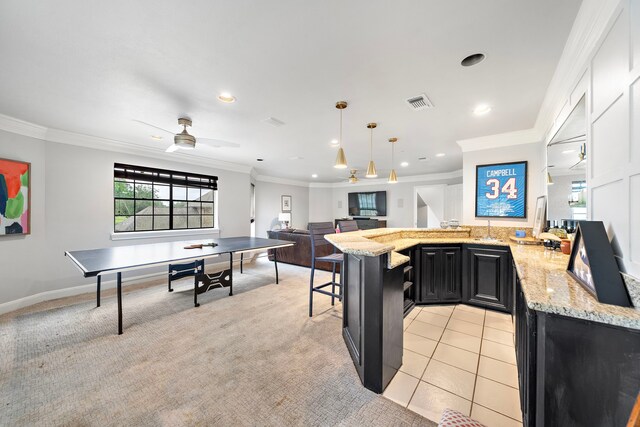 32743 Weybridge St, Fulshear, TX 77441 - kitchen featuring dark cabinetry, crown molding, light stone countertops, recessed lighting, and open floor plan
