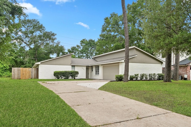 mid-century inspired home featuring fence, a front lawn, brick siding, a garage, and driveway