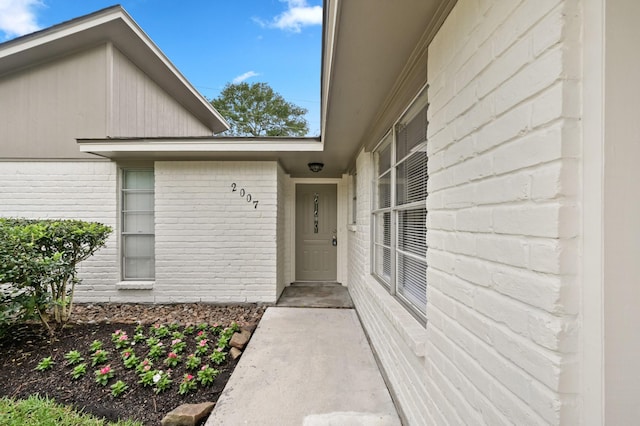 entrance to property featuring brick siding