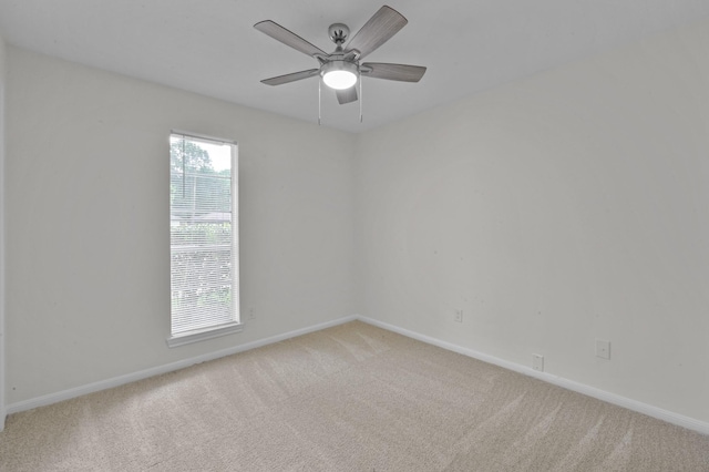 spare room with baseboards and light colored carpet