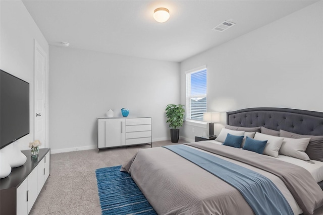 bedroom featuring baseboards, visible vents, and light carpet