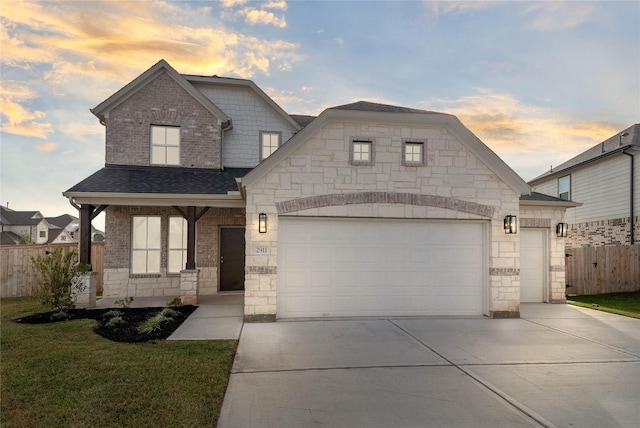 view of front facade with concrete driveway, fence, stone siding, and a garage