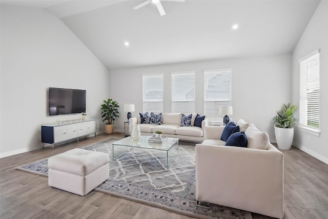 living area with a ceiling fan, wood finished floors, and lofted ceiling