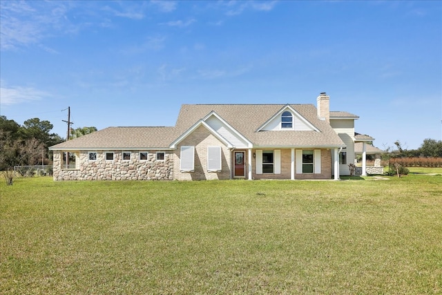 3139 Fm 1406, Winnie, TX 77665 - view of front of house with a shingled roof, a chimney, and a front lawn