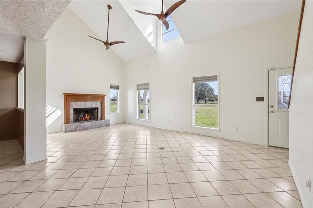 3139 Fm 1406, Winnie, TX 77665 - unfurnished living room featuring light tile patterned floors, high vaulted ceiling, a ceiling fan, and a high end fireplace