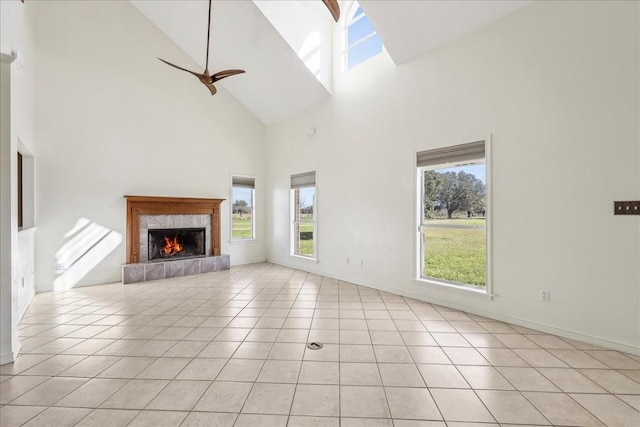 3139 Fm 1406, Winnie, TX 77665 - unfurnished living room with a ceiling fan, a healthy amount of sunlight, high vaulted ceiling, and a tile fireplace