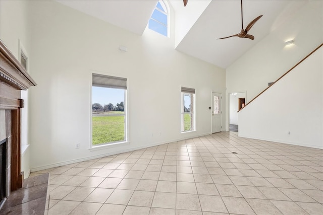 3139 Fm 1406, Winnie, TX 77665 - unfurnished living room with light tile patterned flooring, a fireplace, baseboards, high vaulted ceiling, and a ceiling fan