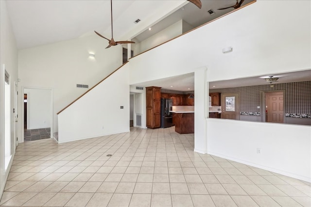 3139 Fm 1406, Winnie, TX 77665 - unfurnished living room with ceiling fan, visible vents, a towering ceiling, stairway, and light tile patterned floors
