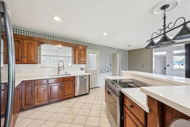 3139 Fm 1406, Winnie, TX 77665 - kitchen featuring a sink, light countertops, a textured ceiling, stainless steel appliances, and light tile patterned floors