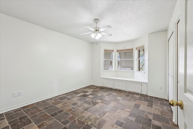 3139 Fm 1406, Winnie, TX 77665 - unfurnished room featuring a ceiling fan, baseboards, stone finish floor, and a textured ceiling