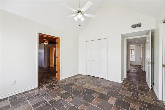 3139 Fm 1406, Winnie, TX 77665 - unfurnished bedroom with stone finish floor, visible vents, baseboards, high vaulted ceiling, and a closet