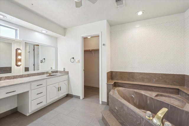 3139 Fm 1406, Winnie, TX 77665 - bathroom featuring vanity, wallpapered walls, a spacious closet, visible vents, and a garden tub