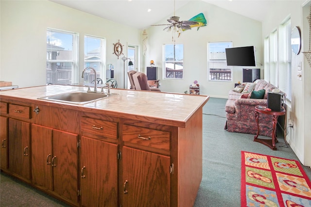 kitchen featuring a ceiling fan, open floor plan, a sink, and carpet