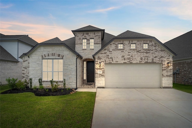23415 Persimmon Creek Ln, Katy, TX 77493 - french country style house with concrete driveway, a yard, stone siding, a shingled roof, and a garage