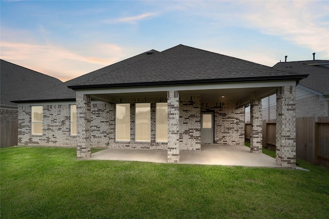 23415 Persimmon Creek Ln, Katy, TX 77493 - back of property at dusk with a shingled roof, a patio area, and a fenced backyard
