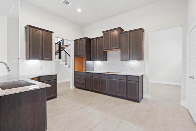23415 Persimmon Creek Ln, Katy, TX 77493 - kitchen with dark brown cabinets, light stone countertops, tasteful backsplash, and recessed lighting