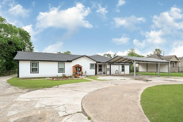 view of front facade featuring curved driveway, a front lawn, and a detached carport