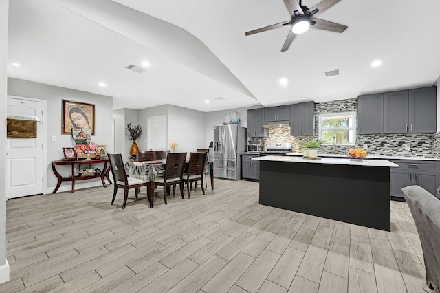 kitchen featuring appliances with stainless steel finishes, visible vents, light countertops, vaulted ceiling, and gray cabinetry