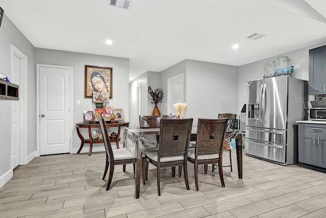 dining space featuring baseboards, visible vents, and light wood-style floors