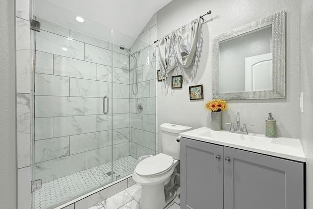 bathroom with a textured wall, vanity, toilet, a shower stall, and lofted ceiling