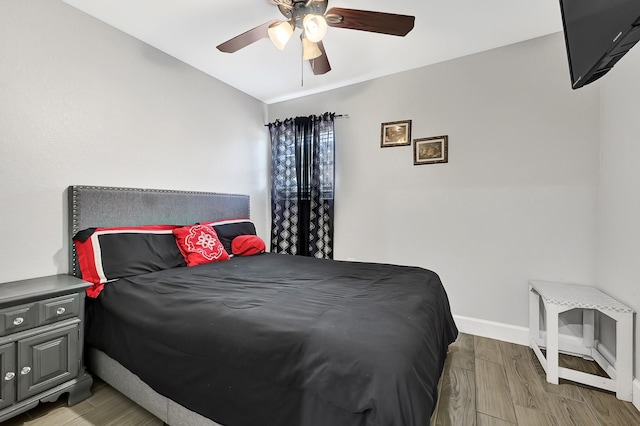 bedroom with baseboards, a ceiling fan, light wood-style flooring, and lofted ceiling