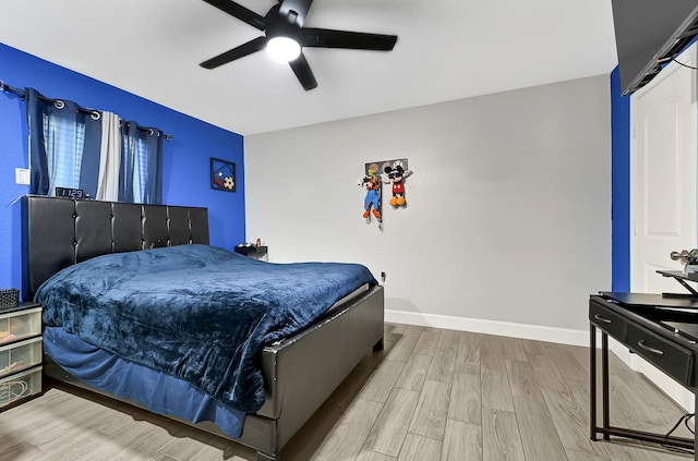 bedroom featuring baseboards, ceiling fan, and wood finished floors