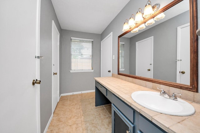 bathroom with baseboards, tile patterned flooring, and vanity
