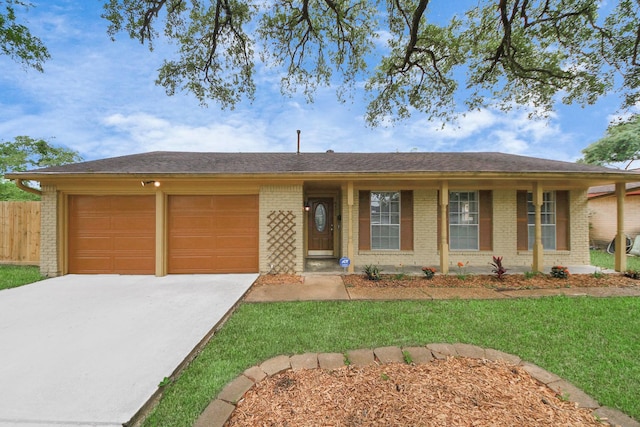 ranch-style home with a front lawn, fence, brick siding, an attached garage, and driveway