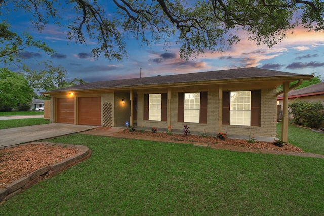 ranch-style home featuring concrete driveway, a lawn, brick siding, and a garage