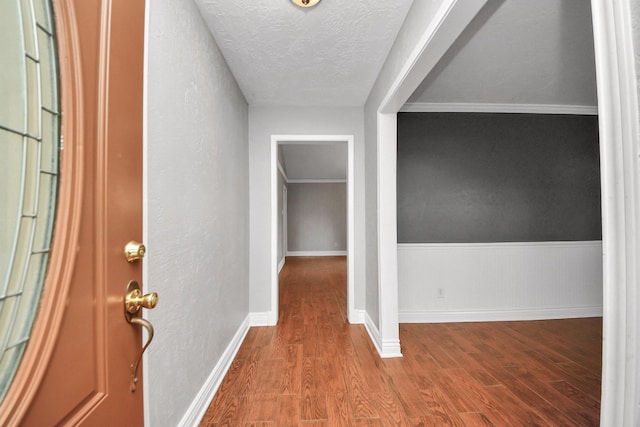entrance foyer with a textured ceiling, baseboards, and wood finished floors