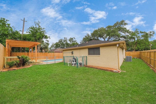 back of property featuring brick siding, central AC, a fenced backyard, a yard, and a pergola