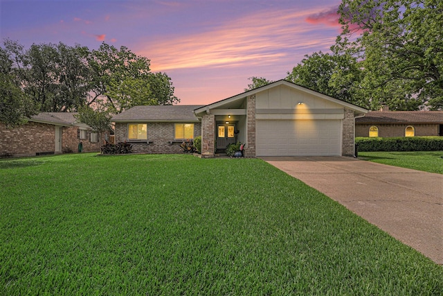 view of front of home featuring brick siding, a garage, a front lawn, and driveway