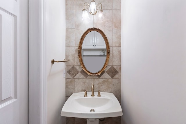 bathroom with a sink and tile walls