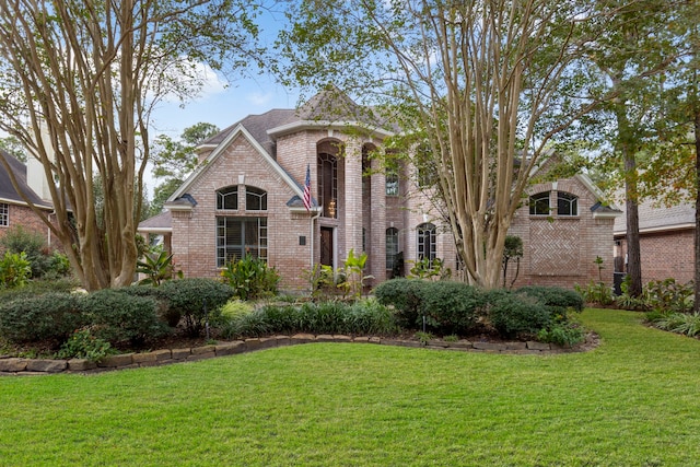 view of front of house featuring a front yard and brick siding