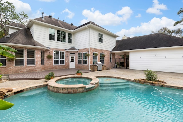 back of house featuring brick siding, a deck, a pool with connected hot tub, and a patio area