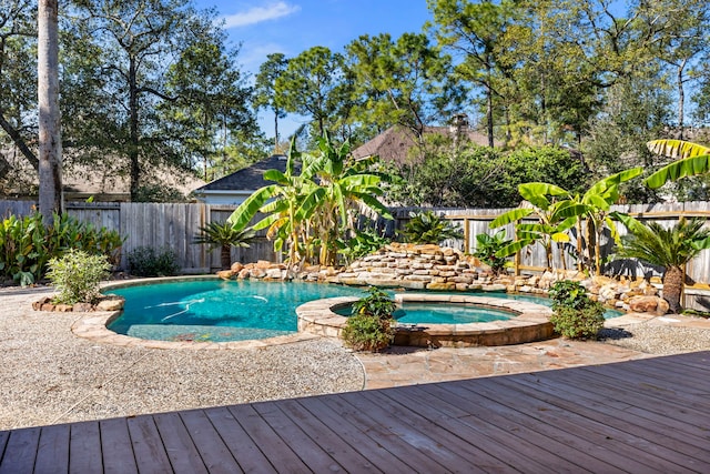view of pool with a fenced backyard, a fenced in pool, an in ground hot tub, and a deck