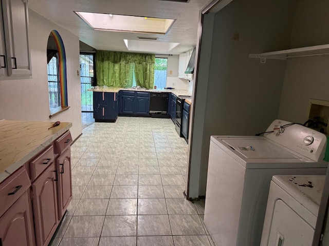 laundry room with separate washer and dryer, laundry area, a skylight, and light tile patterned floors