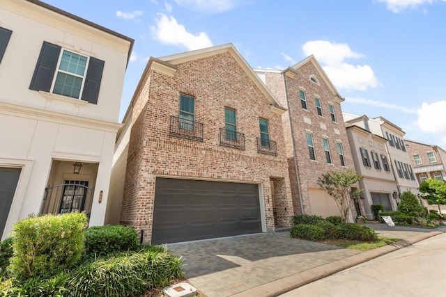 multi unit property featuring an attached garage, stucco siding, driveway, and brick siding
