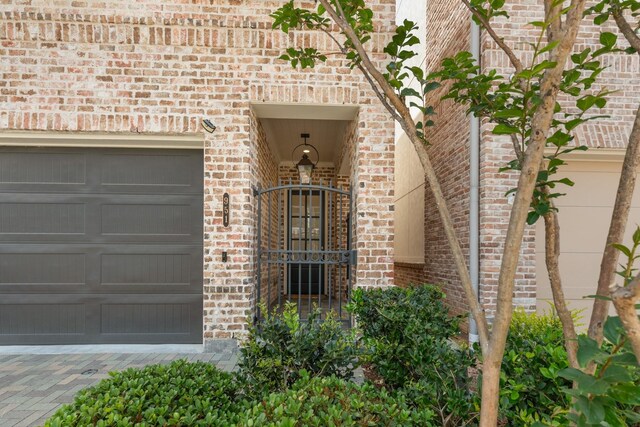 property entrance featuring brick siding and an attached garage