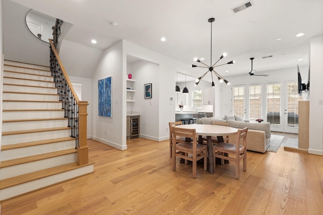 dining area with visible vents, baseboards, wine cooler, and stairs