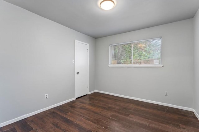 unfurnished room with baseboards and wood finished floors