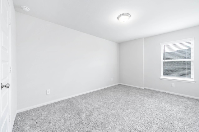empty room featuring baseboards and carpet