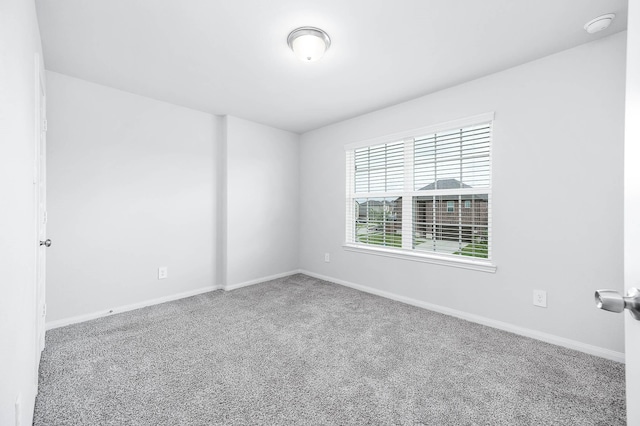 carpeted spare room with baseboards