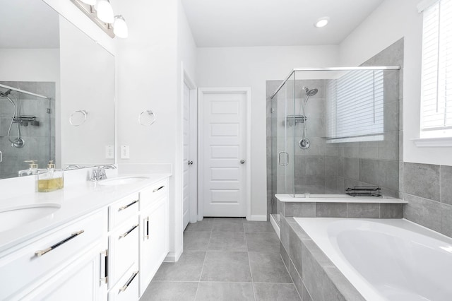 bathroom with a garden tub, double vanity, tile patterned floors, a sink, and a stall shower