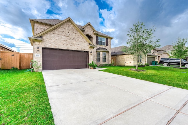 french provincial home featuring a front lawn, fence, brick siding, an attached garage, and driveway