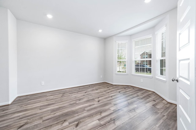 unfurnished room with recessed lighting, baseboards, and wood finished floors